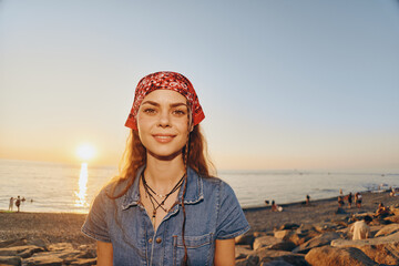 Lifestyle woman in modern boho-western denim street style with a red bandana, warm sunset, and...