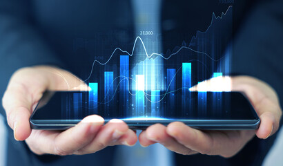 Business man holding telephone and showing holographic graphs and stock market statistics gain...
