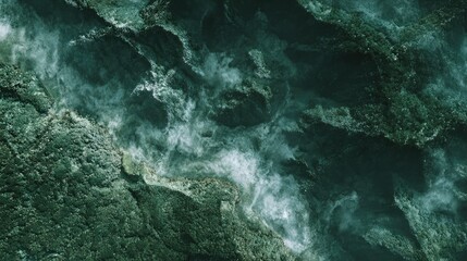 Obraz premium Close-up of flowing water over dark, textured rocks