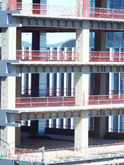 Close-up view of a modern building under construction, showing multiple concrete floors with safety...