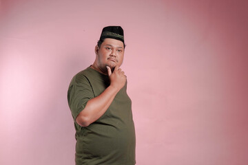 A man in a green shirt is looking down at his chin. He is deep in thought