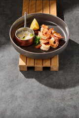 Fried shrimp with garlic, bright overhead, minimalist composition, served with dip and lemon wedge