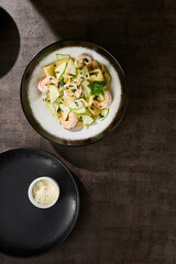 Pappardelle pasta with zucchini and shrimp, bright rustic mood, overhead composition