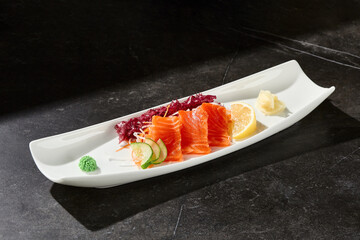 Salmon sashimi with cucumber and lemon, bright lighting, overhead composition