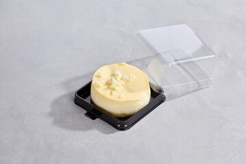 Mini cheesecake in plastic box, bright lighting, overhead composition