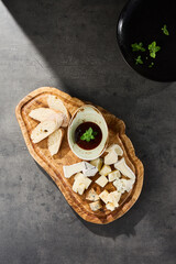 Cheese platter with brie, parmesan, camembert, and gorgonzola on wooden board, bright overhead...