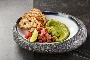 Tuna tartare with avocado mousse in bright rustic overhead plate composition