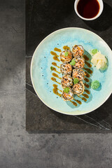Tempura salmon roll, spicy maki, bright overhead plate with sauce drizzle, minimal light composition