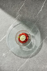 Basil ice cream with strawberry tartare, bright overhead shot on textured glass plate