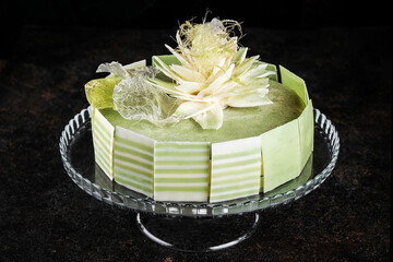 An Elegant Green Cake Beautifully Decorated with Exquisite Floral Toppers