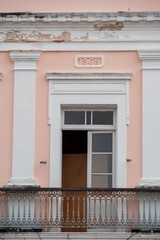 Historic building facade with ornate balcony and '1868' date in pastel colors.