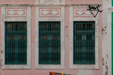 Obraz na płótnie Canvas Vintage architecture with green shutters on a pink wall