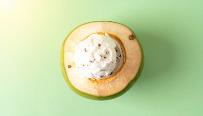 Top-down view of a fresh coconut half filled with a scoop of creamy ice cream.