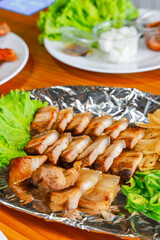 Korean grilled pork belly with dipping sauces and lettuce
