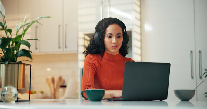 Headphones, laptop and remote work with woman in kitchen of home for update or virtual meeting. Coffee, computer and video call with freelance employee in apartment for communication or webinar