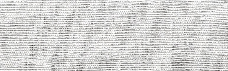 Obraz premium Close-up view of a textured, light gray fabric. Fine, parallel lines create a woven pattern. The light gray color is consistent throughout the image