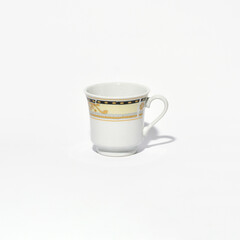Elegant porcelain coffee mug with yellow and black decorative pattern on clean background