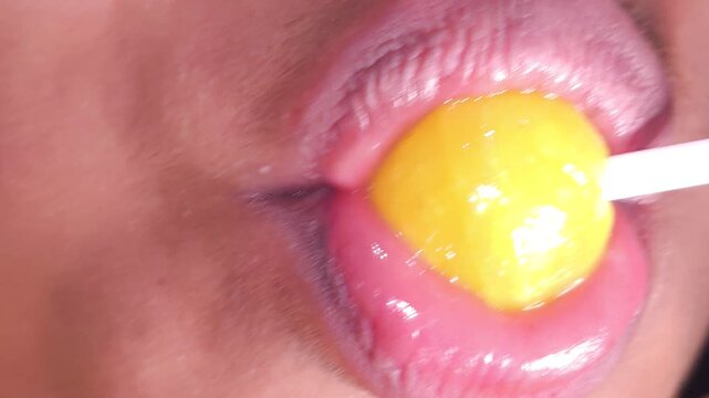 Lollipops, Female mouth licks sweet stick candy. Sexy Indian girl eating popsicles or chupa chups close-up. Woman lips sucking Tootsie Pops. Sensual sex shop concept. Sexual dreams. Pleasure. 