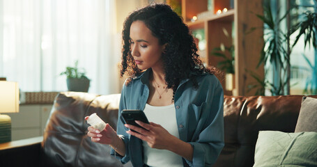 Medication, phone and reading with woman on sofa in living room of home for prescription information. Container label, supplements or vitamins with person in apartment for healthcare research