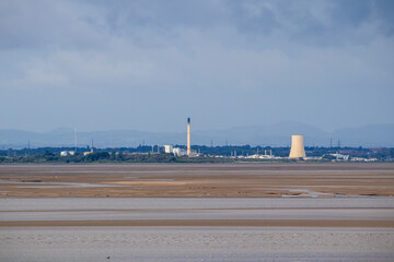 Industrial site with cooling tower and chimney on the banks of the River Mersey