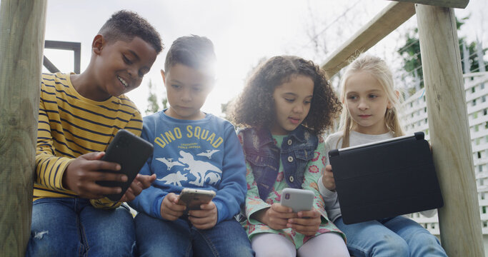 Friends, kids and smile with tech in park for social media, fun and break in backyard. Children, together and bonding with phone, tablet and internet for school holiday in playground with games