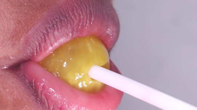 Lollipops, Female mouth licks sweet stick candy. Sexy Indian girl eating popsicles or chupa chups close-up. Woman lips sucking Tootsie Pops. Sensual sex shop concept. Sexual dreams. Pleasure. 