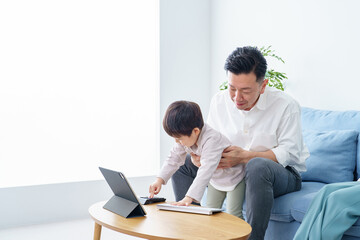 Obraz premium テレワークする父親を邪魔する子ども
