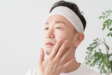 肌の状態をチェックするミドル男性
