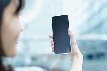 スマートフォンを操作するビジネスウーマン