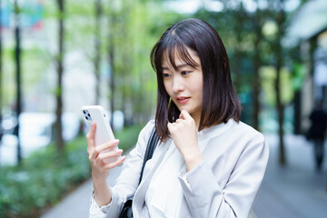 困った表情で電話するビジネスウーマン