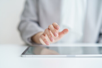 タブレットPCを操作する女性の手元 © TAGSTOCK2