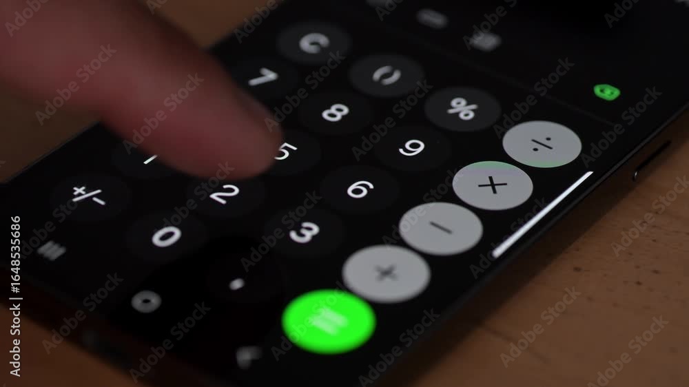 Poster a close-up of a finger pressing a button on a smartphone calculator app. the bright numeric keys and