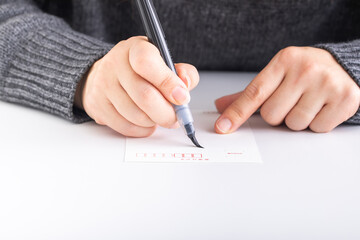 筆で手紙を書く女性の手