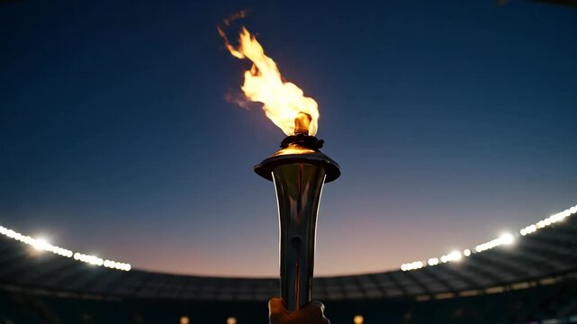Olympic Torch Blazing at Dusk - A close-up shot of an Olympic torch ablaze, held aloft against a twilight sky.