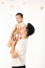 An 18-month-old Asian boy wrapped in a bath towel, walking with a superhero pose