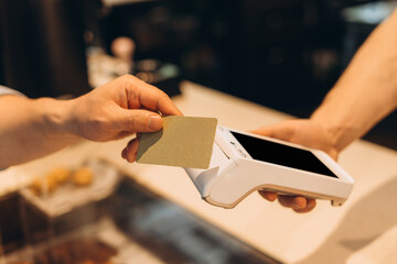 Customer paying with contactless credit card at pos terminal