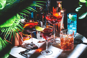 Set of alcoholic cocktails drinks with bottles on a marble table in a cozy environment of tropical...