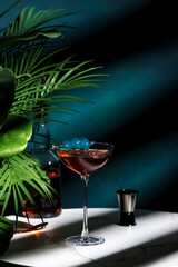 Strong alcoholic cocktail drink with whiskey, vermouth, bitters and blue cherry. Marble table,...