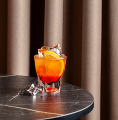 Delight in a refreshing bicicletta cocktail garnished with orange, served in a stylish setting