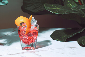 Tegroni, alcoholic cocktail drink with tequila, red bitters, sweet vermouth and orange peel. Marble...
