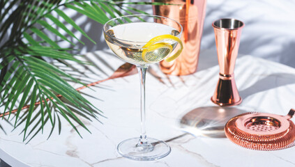 Transparent alcoholic cocktail drink with gin, vermouth, liqueur, absinthe, bitters and lemon twist