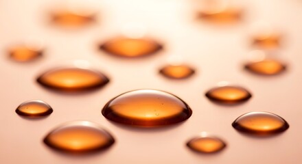 Close up of amber colored water droplets on a light surface