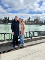 Couple's Leisure: A couple, immersed in their leisure, poses beside a tranquil lake, with...
