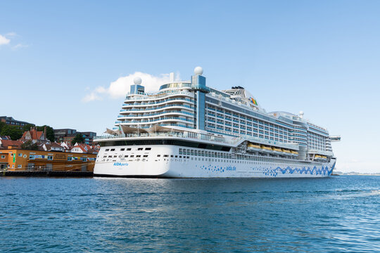 31 july 2025, Stavanger, Norway. Aida perla cruise ship lying in harbor  of Stavanger. Part of old town Stavanger visible. Big cruise ship in Norway, mass tourism.