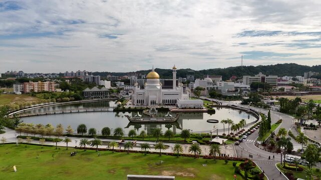 Cinematic zoom in aerial drone shot of the man made lagoon surrounding the Omar Ali Saifuddien Mosque in Brunei.