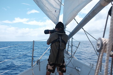 Photographer on Sailboat Taking Pictures Over Open Ocean