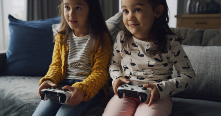 Home, kids and play video game for competition, contest and entertainment on sofa. Sisters, girls and children with console for gaming challenge, hobby and relax together with family in lounge