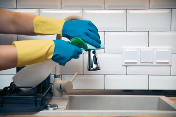 Using cleaning products for cleaning table in kitchen at home. Housekeeping, household chores.