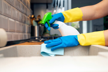 Using cleaning products for cleaning table in kitchen at home. Housekeeping, household chores.