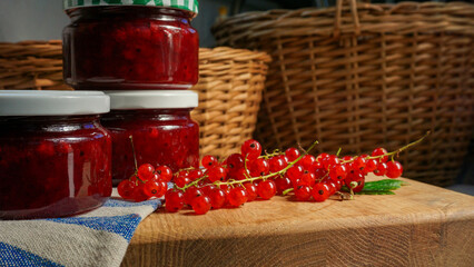 Rustic arrangement of homemade red currant jam jars by some fresh currant berries. Homemade...